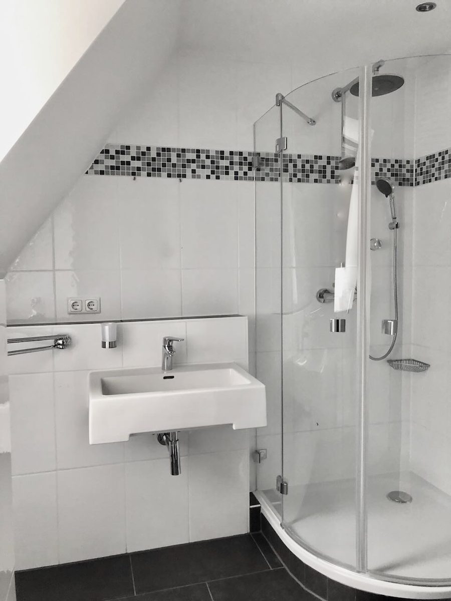 Badezimmer im Dachgeschoss mit Glas-Eckdusche und Dachschräge